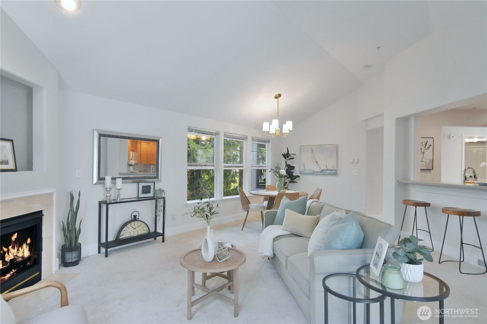 8500 Main Street, Unit F313 Edmonds, WA 98026 - Photo 7 of 24 a living room with furniture a fireplace and a floor to ceiling window