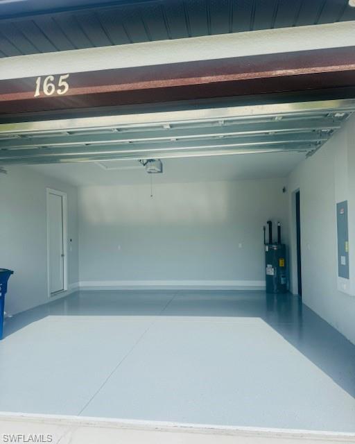 165 Patio Street Lehigh Acres, FL 33974 - Photo 10 of 34 Garage featuring water heater and electric panel