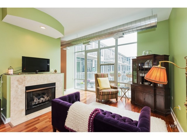 901 West Madison Street, Unit 905 Chicago, IL 60607 - Photo 2 of 10 a living room with furniture a fireplace and a flat screen tv