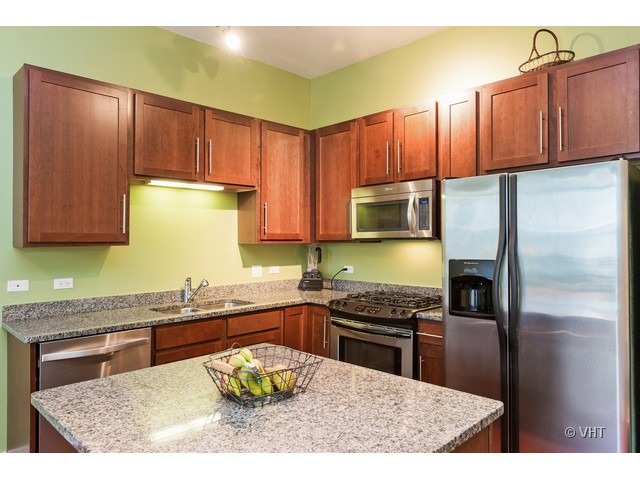901 West Madison Street, Unit 905 Chicago, IL 60607 - Photo 4 of 10 a kitchen with stainless steel appliances granite countertop a stove refrigerator sink and cabinets