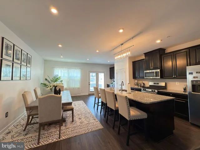 a view of a dining room with furniture a kitchen and chandelier