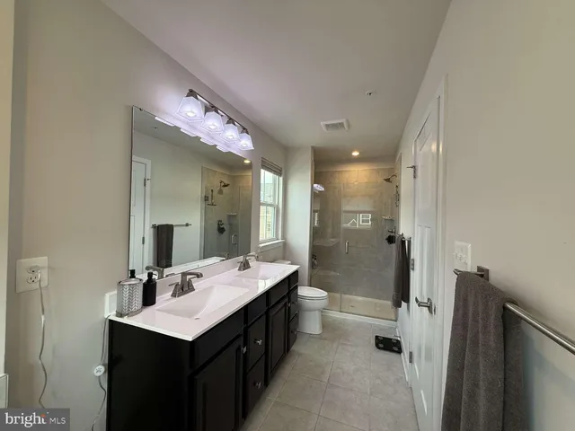 a bathroom with a double vanity sink mirror and shower