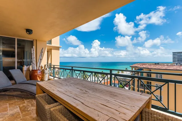 a balcony with wooden floor table and chairs