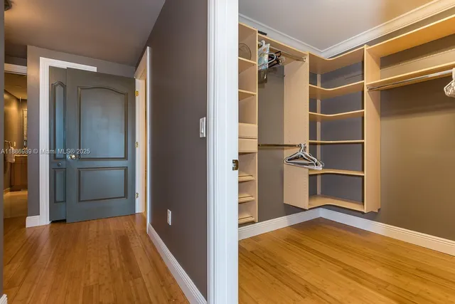 a view of walk in closet with wooden floor