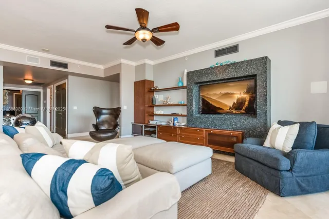 a living room with furniture ceiling fan and a flat screen tv