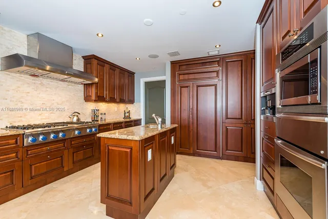 a kitchen with stainless steel appliances granite countertop a stove a sink and a refrigerator