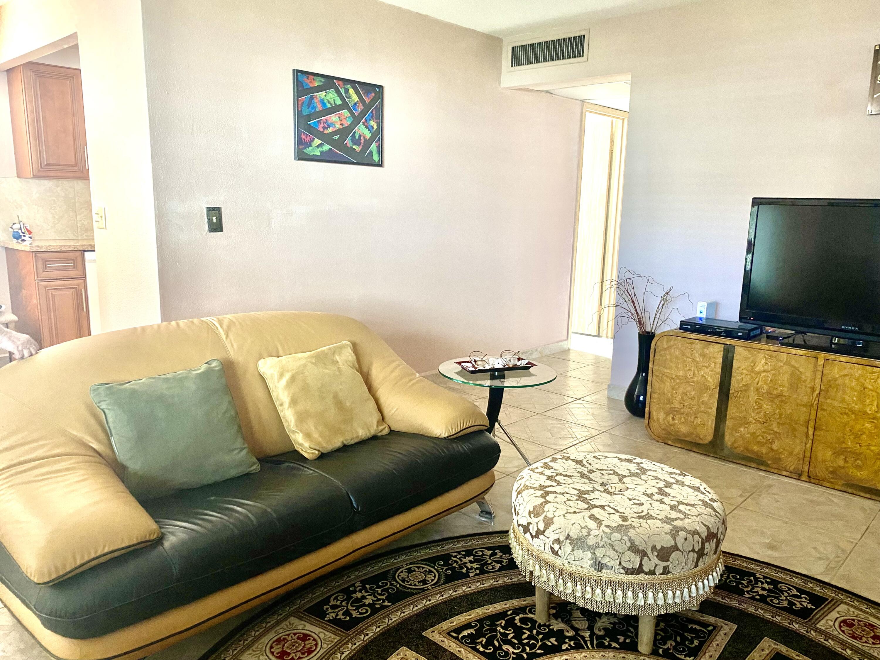 64 Flanders B, Unit 64 Delray Beach, FL 33484 - Photo 3 of 35 a living room with a couch and a flat screen tv