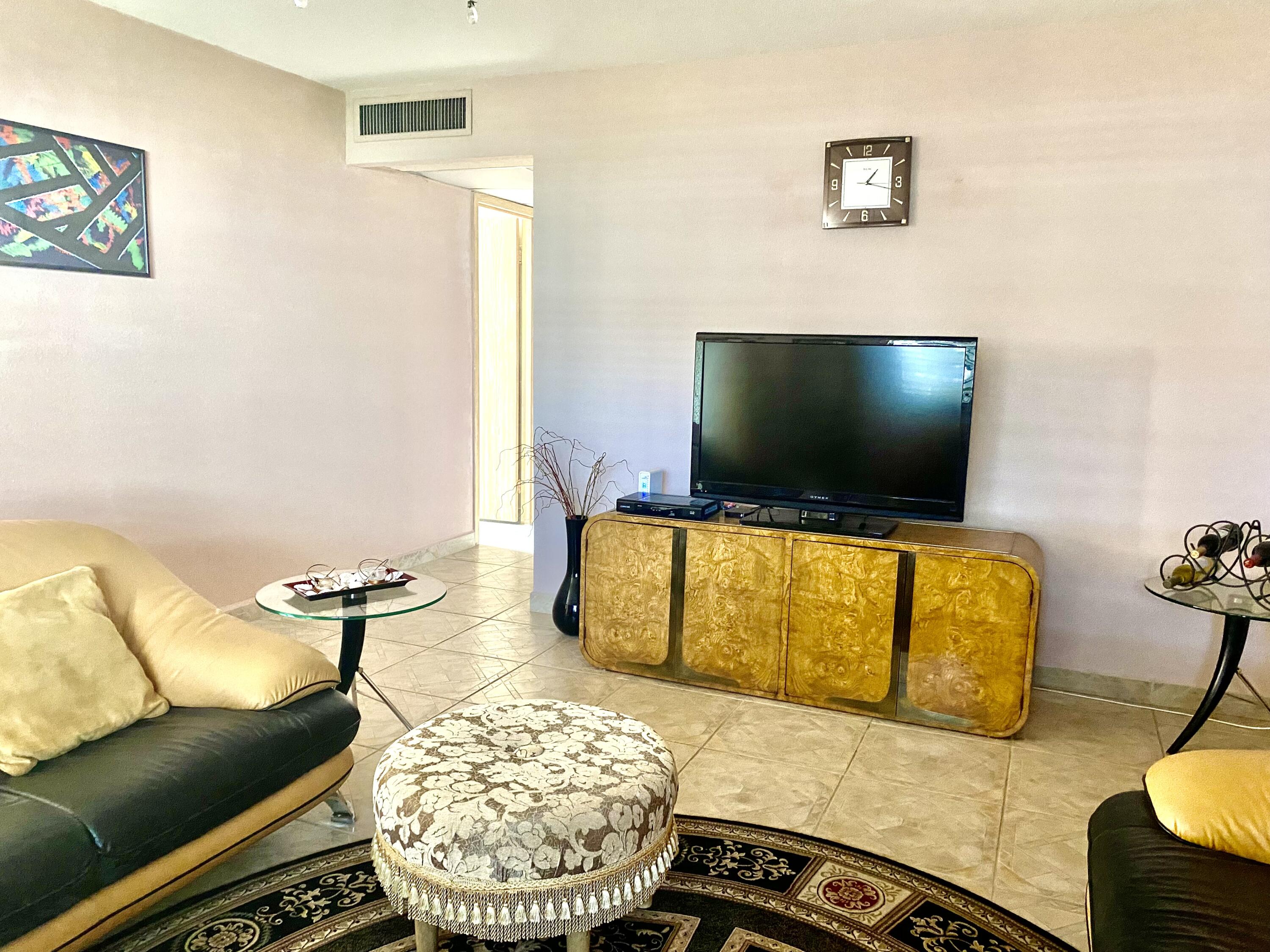 64 Flanders B, Unit 64 Delray Beach, FL 33484 - Photo 4 of 35 a living room with furniture and a flat screen tv