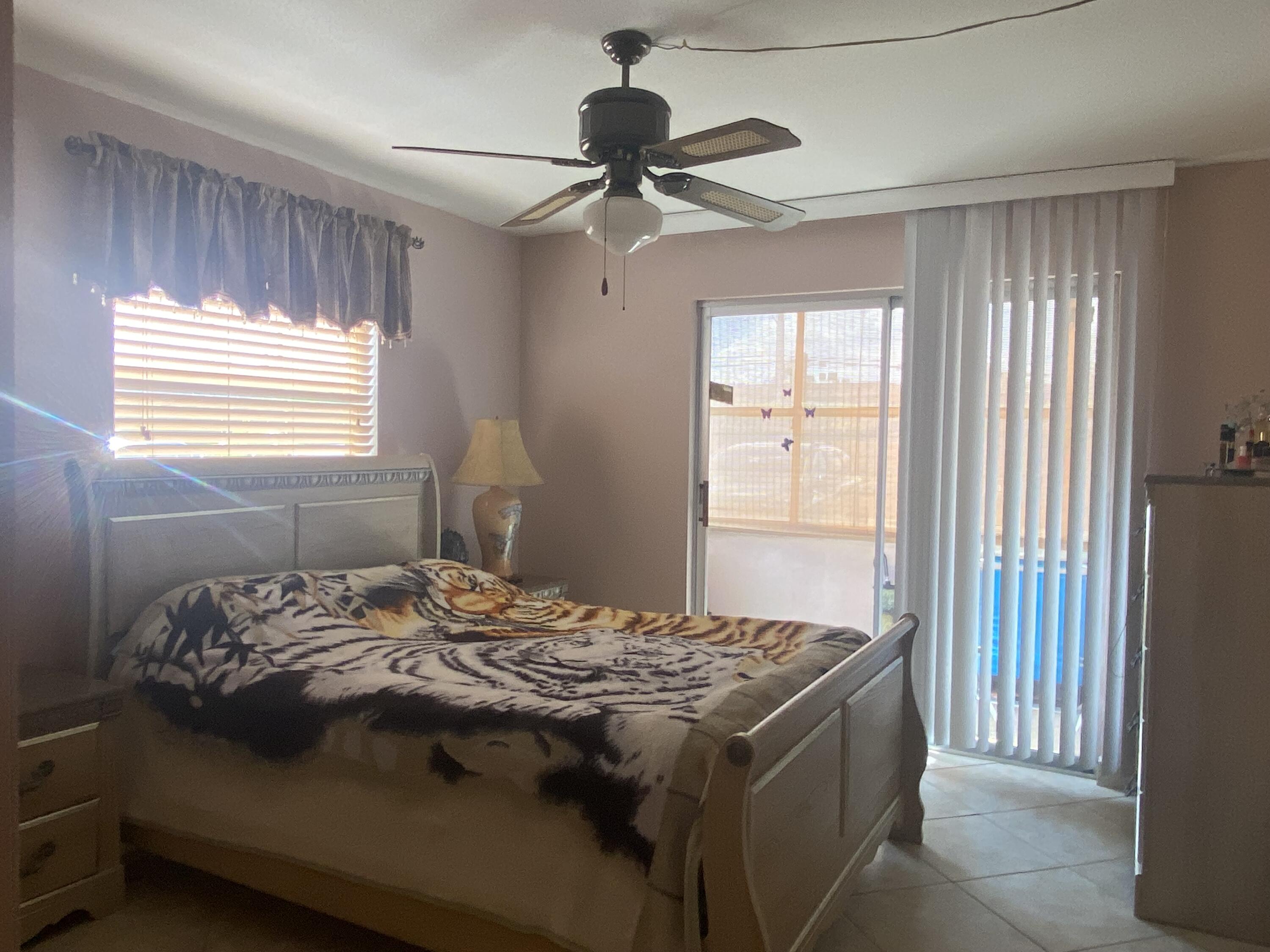 64 Flanders B, Unit 64 Delray Beach, FL 33484 - Photo 10 of 35 a bedroom with a bed and a chandelier