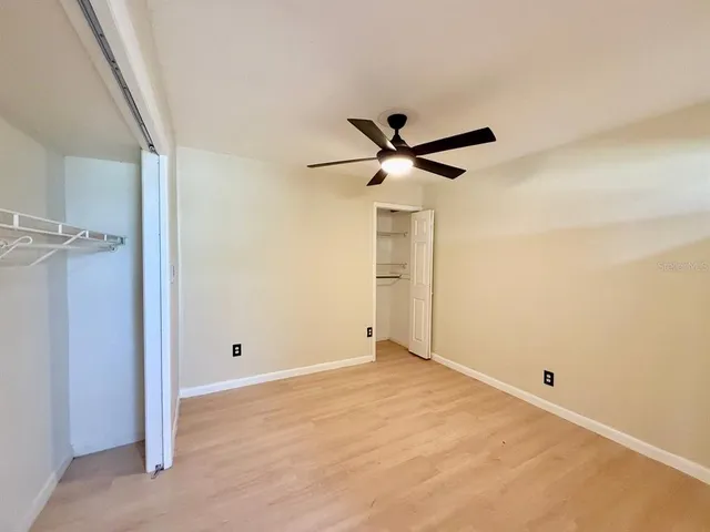 a view of a big room with closet and a ceiling fan