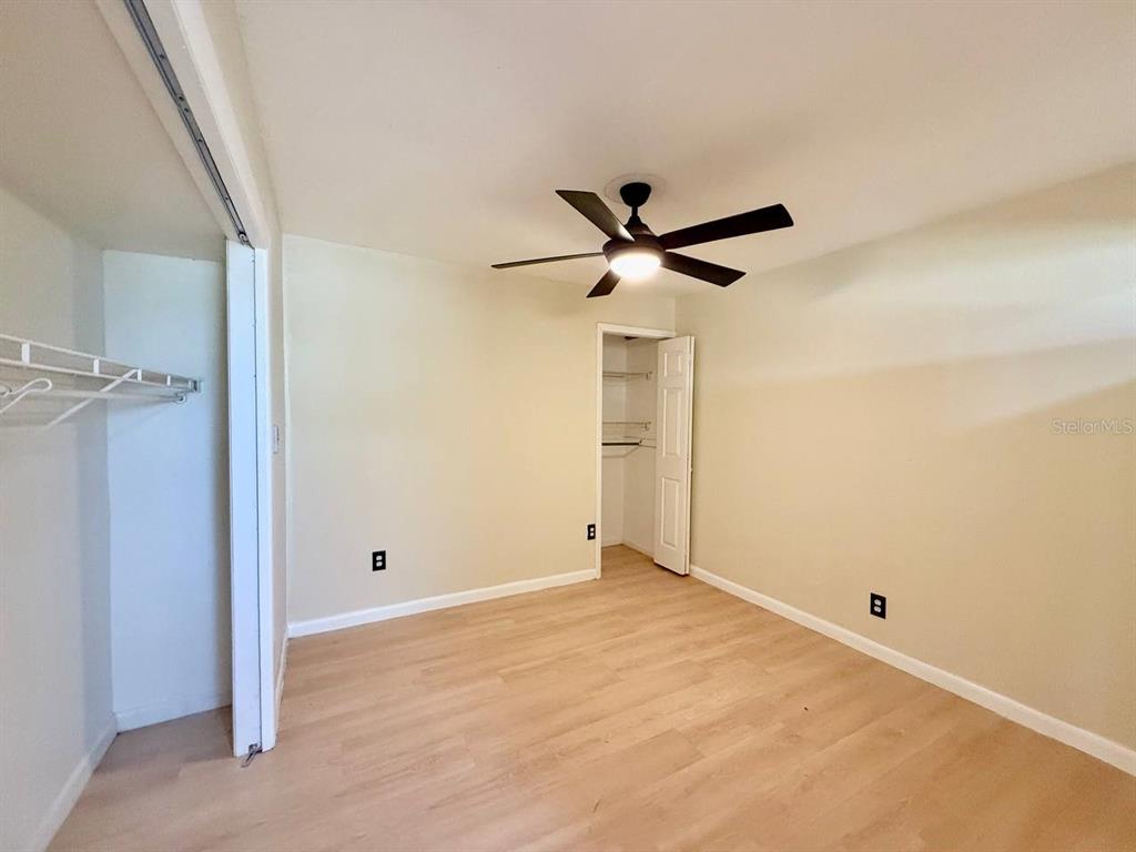 804 East 127th Avenue, Unit B Tampa, FL 33612 - Photo 10 of 16 a view of a big room with closet and a ceiling fan