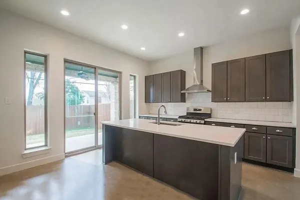 a kitchen with stainless steel appliances granite countertop a stove a sink and a refrigerator