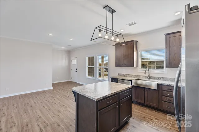 a kitchen with a sink a center island and cabinets