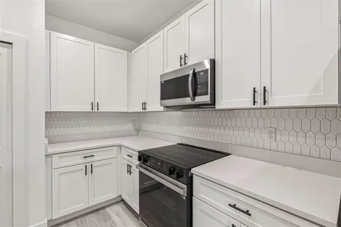 a view of a kitchen with white cabinets