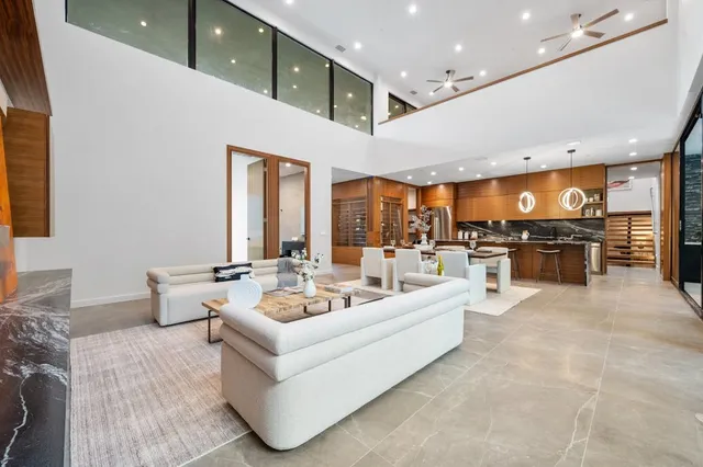 a living room with furniture kitchen view and a large window