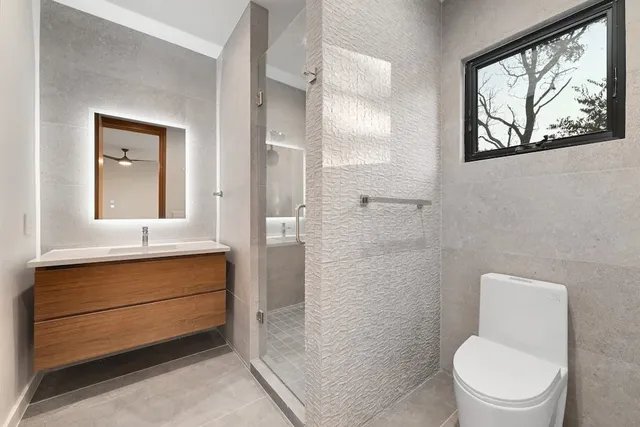 a bathroom with a toilet a sink and glass door