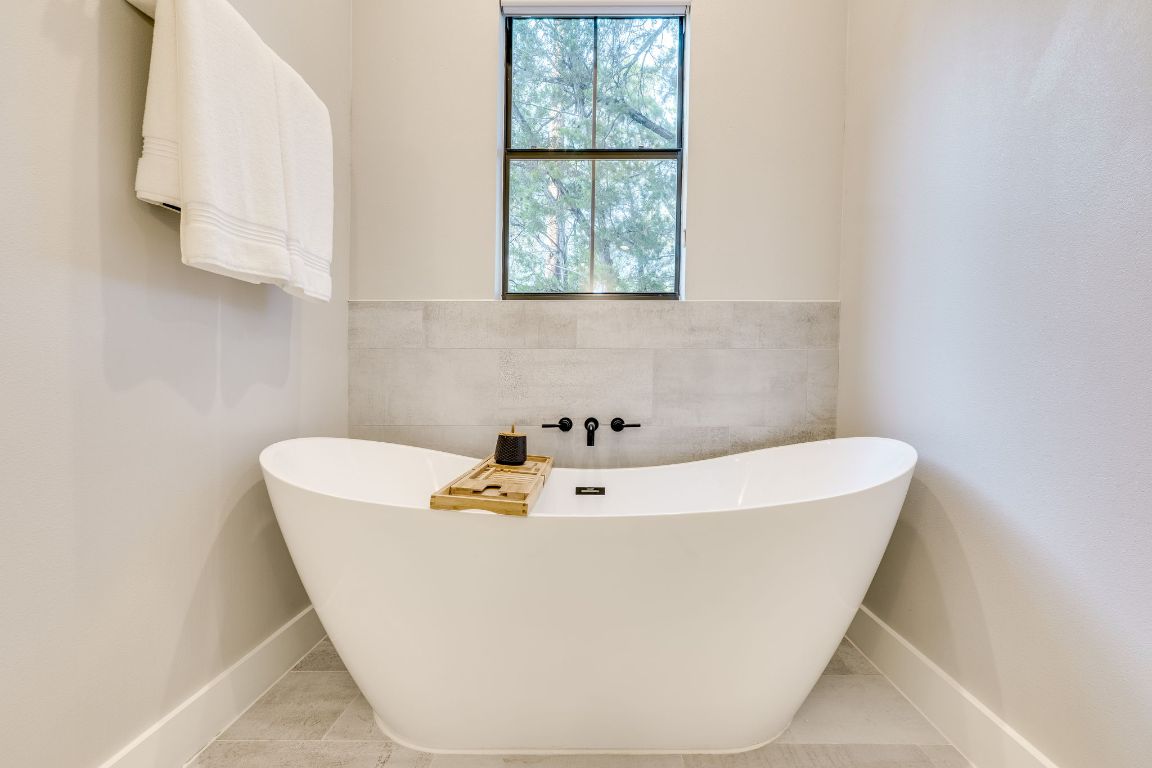 5904 Hudson Bend Road Austin, TX 78734 - Photo 22 of 37 The primary ensuite features this deep soaking tub, quartz countertops and dual vanities.