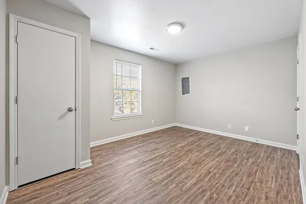 an empty room with wooden floor and windows