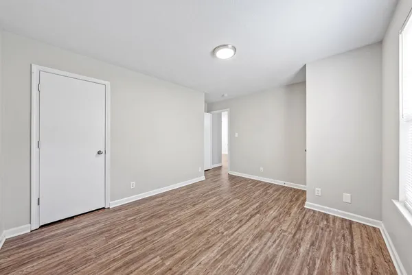 a view of an empty room with wooden floor