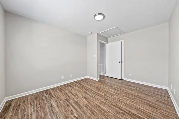 a view of an empty room with wooden floor