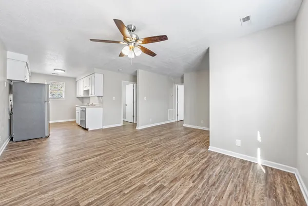 a view of empty room with wooden floor and window