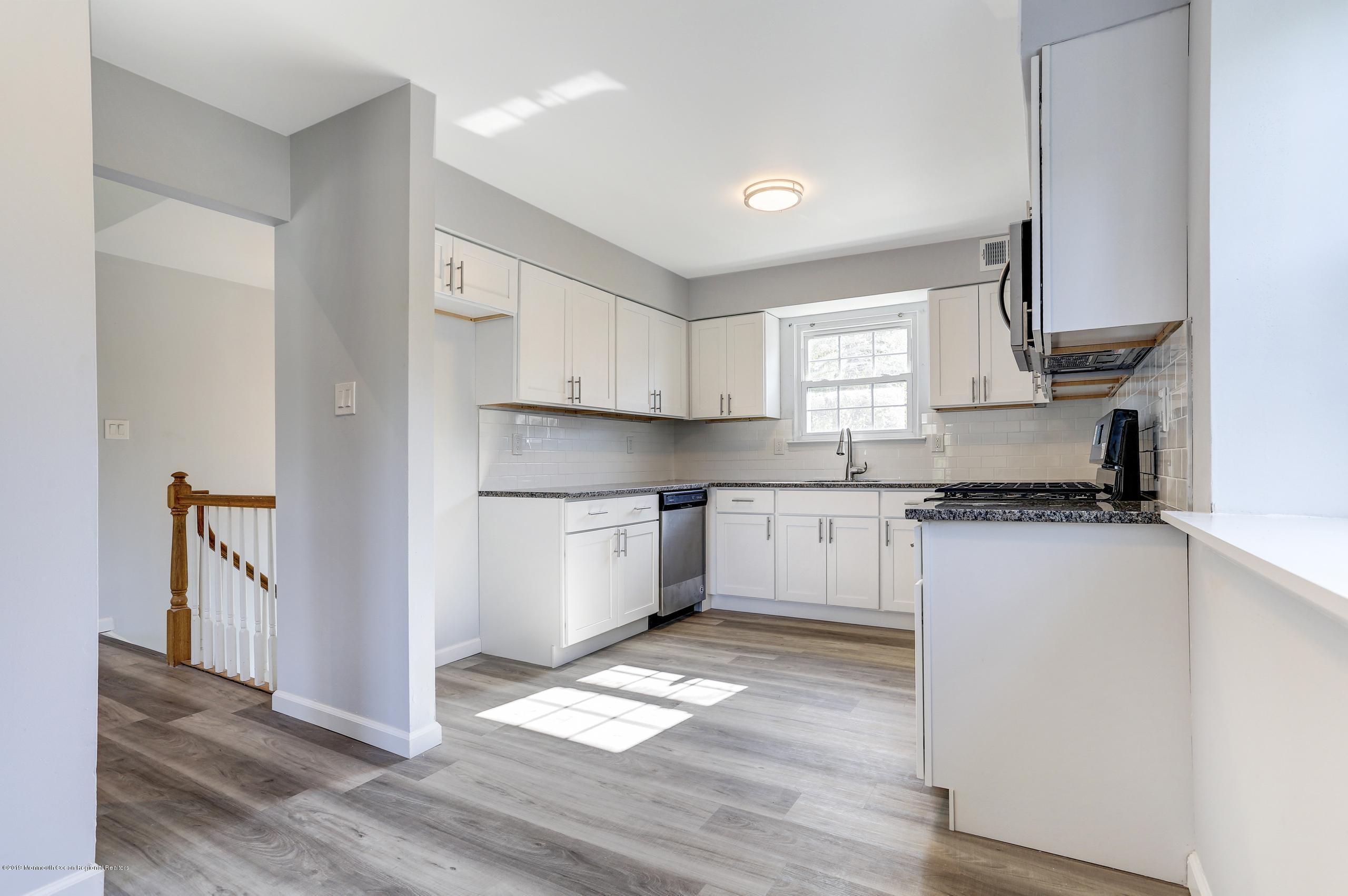 32 Hedgewood Road Howell, NJ 07731 - Photo 17 of 30 a kitchen with granite countertop white cabinets and white appliances