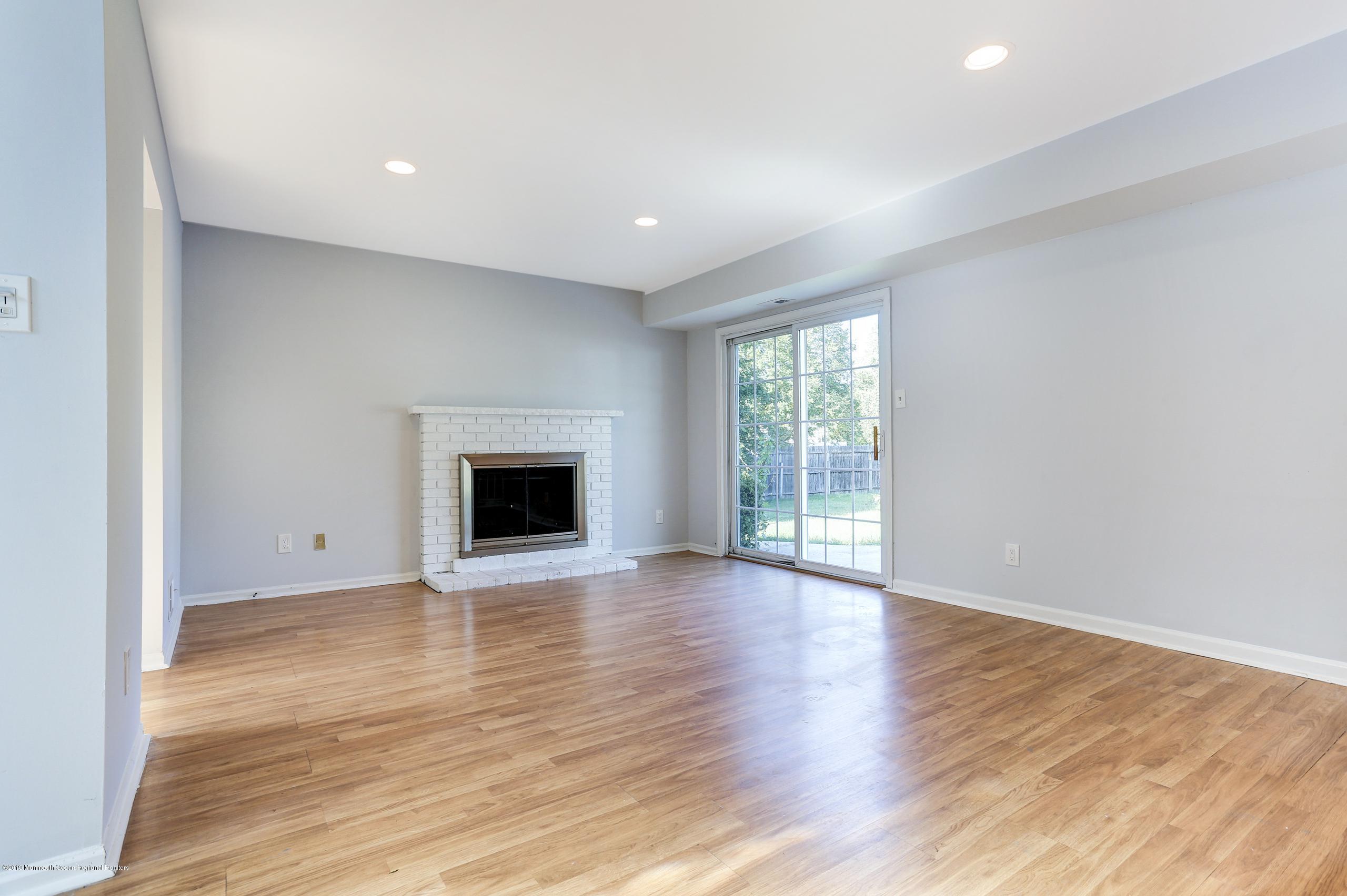 32 Hedgewood Road Howell, NJ 07731 - Photo 24 of 30 an empty room with wooden floor and fireplace