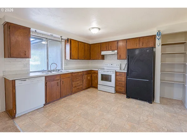 a kitchen with stainless steel appliances granite countertop a refrigerator and a sink