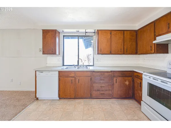 a open kitchen with stainless steel appliances granite countertop a stove and a refrigerator