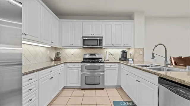 a kitchen with cabinets appliances a sink and a counter top