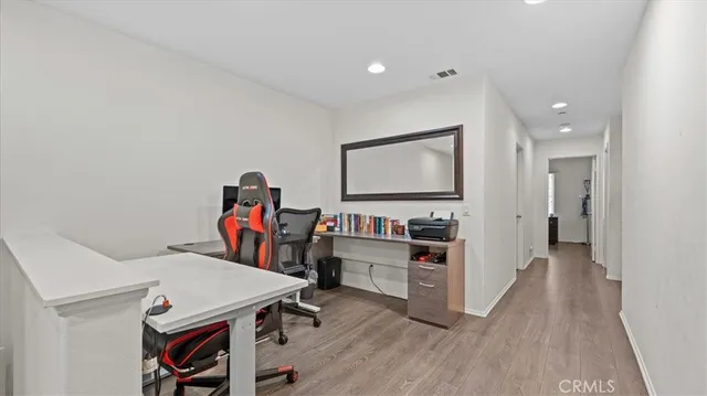a view of a workspace with furniture and wooden floor