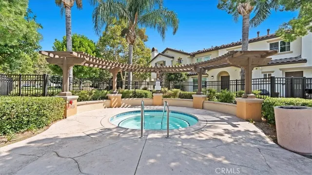 a patio with a table and chairs and potted plants