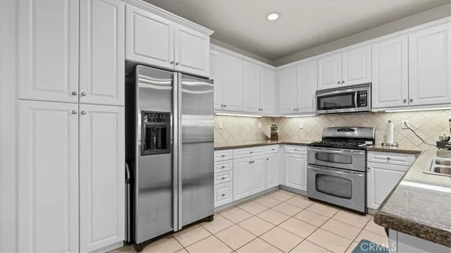 a kitchen with cabinets stainless steel appliances and a counter space