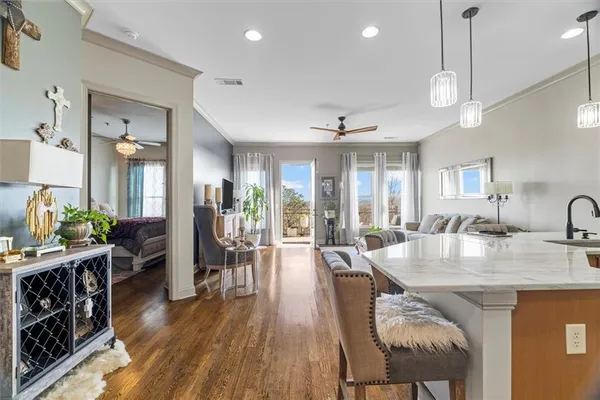 a view of a dining room and livingroom with furniture wooden floor a chandelier