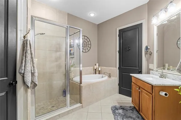 a bathroom with a tub sink mirror and shower
