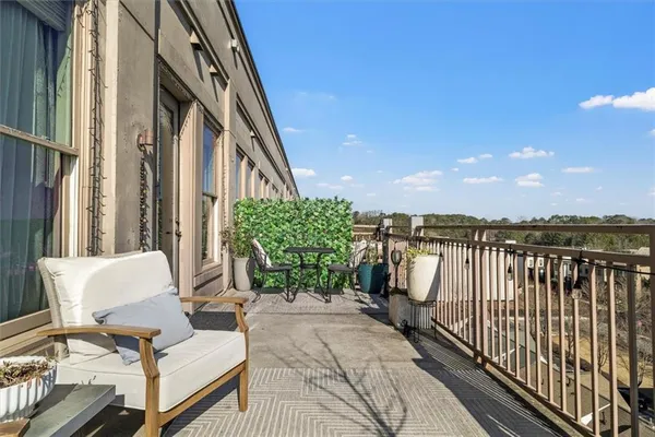 a balcony with chairs and with potted plants