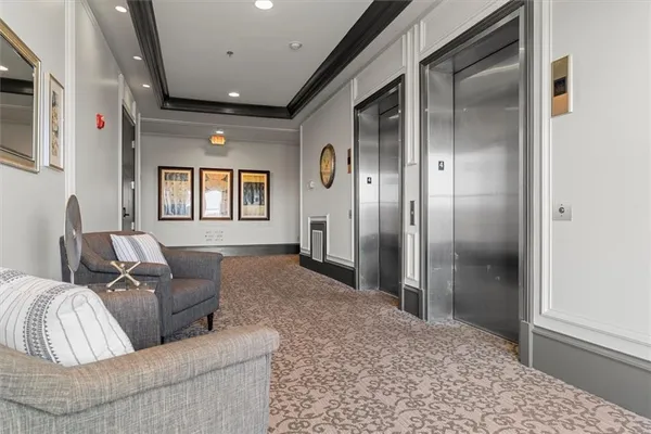 a living room with couches and a refrigerator