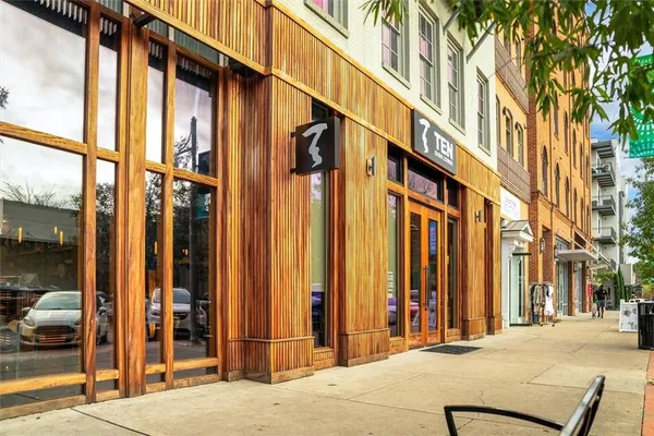 a front view of a building with glass windows and a garage