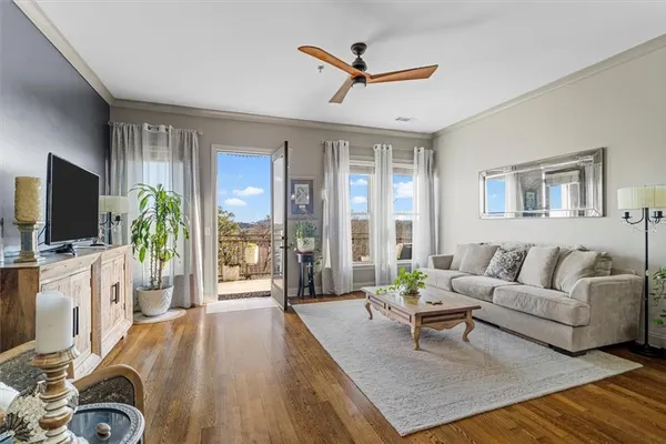 a living room with furniture a flat screen tv and a large window
