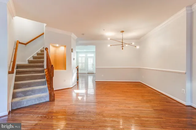 a view of an empty room with wooden floor and windows