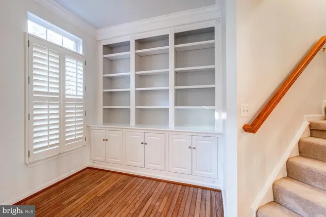 a kitchen with stainless steel appliances granite countertop a refrigerator a sink dishwasher a stove and white countertops with wooden floor