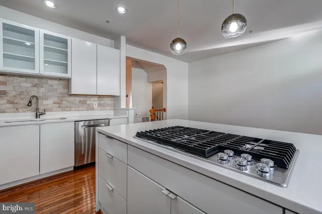 a kitchen with granite countertop a refrigerator and a sink