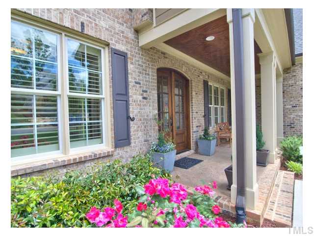 Arched Mahogany & Beveled Glass Front Entry Doors greet you from the street side,a covered front porch with natural stained wainscoting ceiling is what we call 'gravy on the biscuit' to beckon you inside and see what awaits your surprise.
