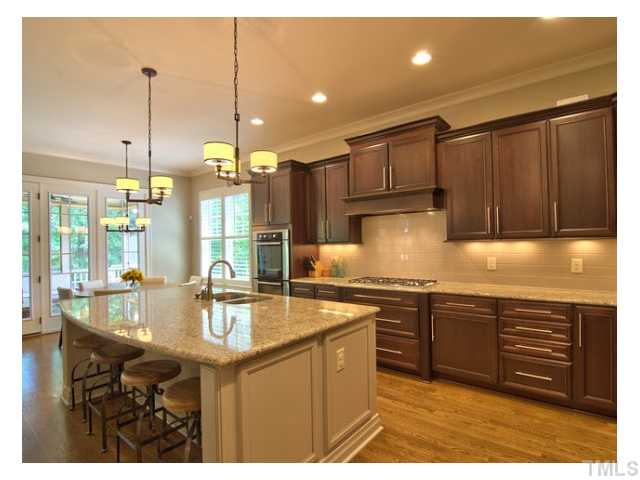 7916 Longleaf Branch Court Raleigh, NC 27612 - Photo 9 of 25 6 Burner Gas Cooktop w/ range hood vented to outside, your "Carolina Living Room" (screen porch) is straight out the triple French Doors. Where shall we eat? Um, the eat-in kitchen island, the breakfast room (flowers on table) or the formal dining room?