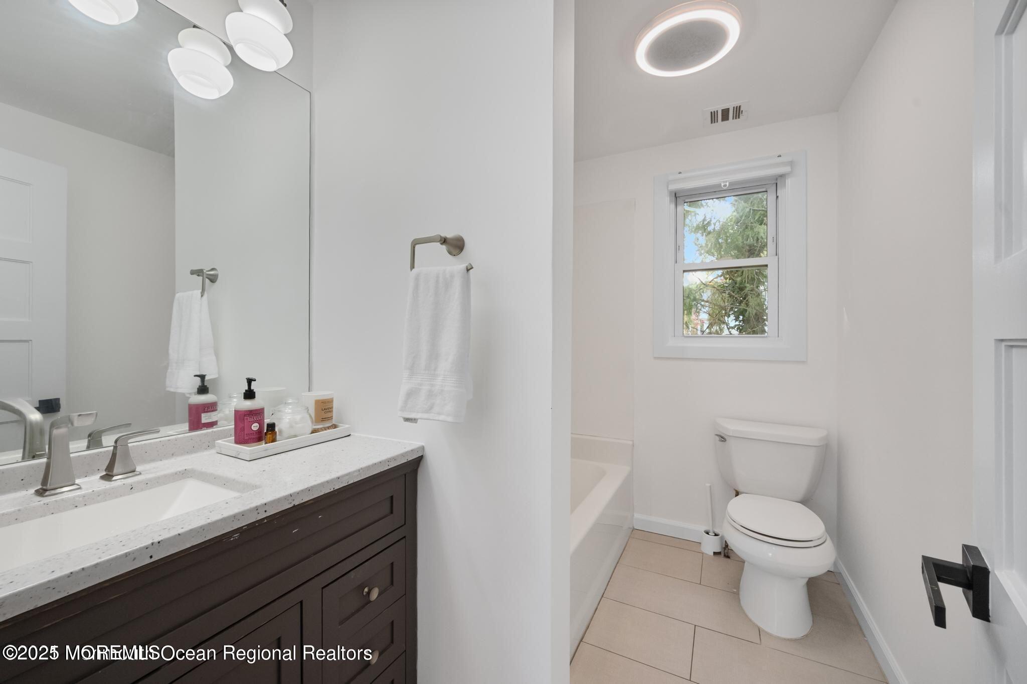 300 Monmouth Road West Long Branch, NJ 07764 - Photo 6 of 10 a bathroom with a granite countertop sink a toilet and a mirror