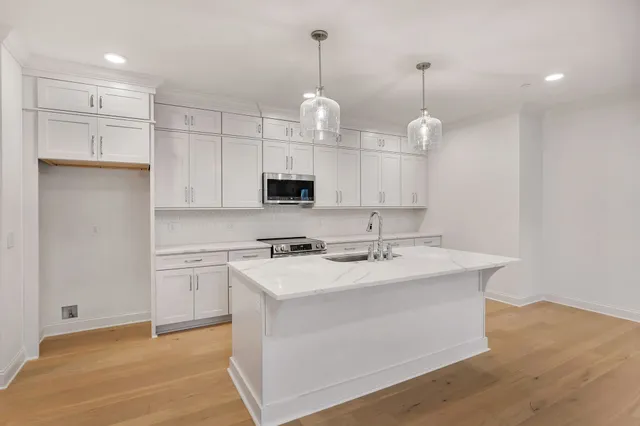 a kitchen with kitchen island a sink stainless steel appliances and cabinets