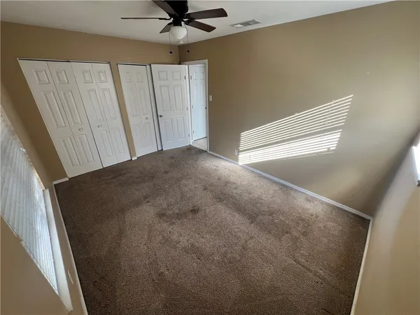 a view of a hallway with a ceiling fan
