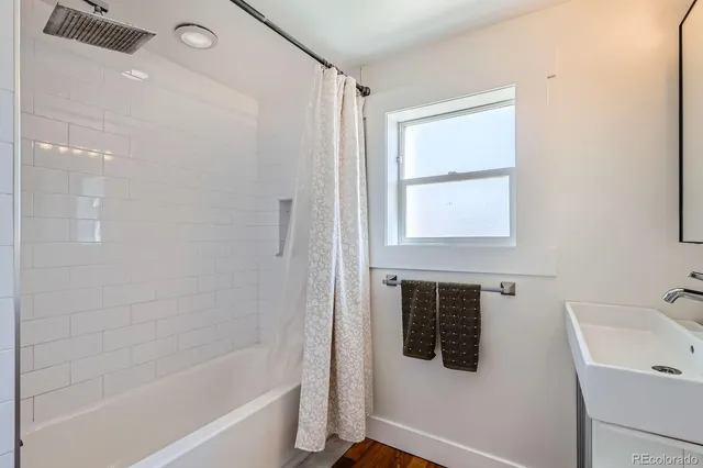 a bathroom with a tub sink and mirror