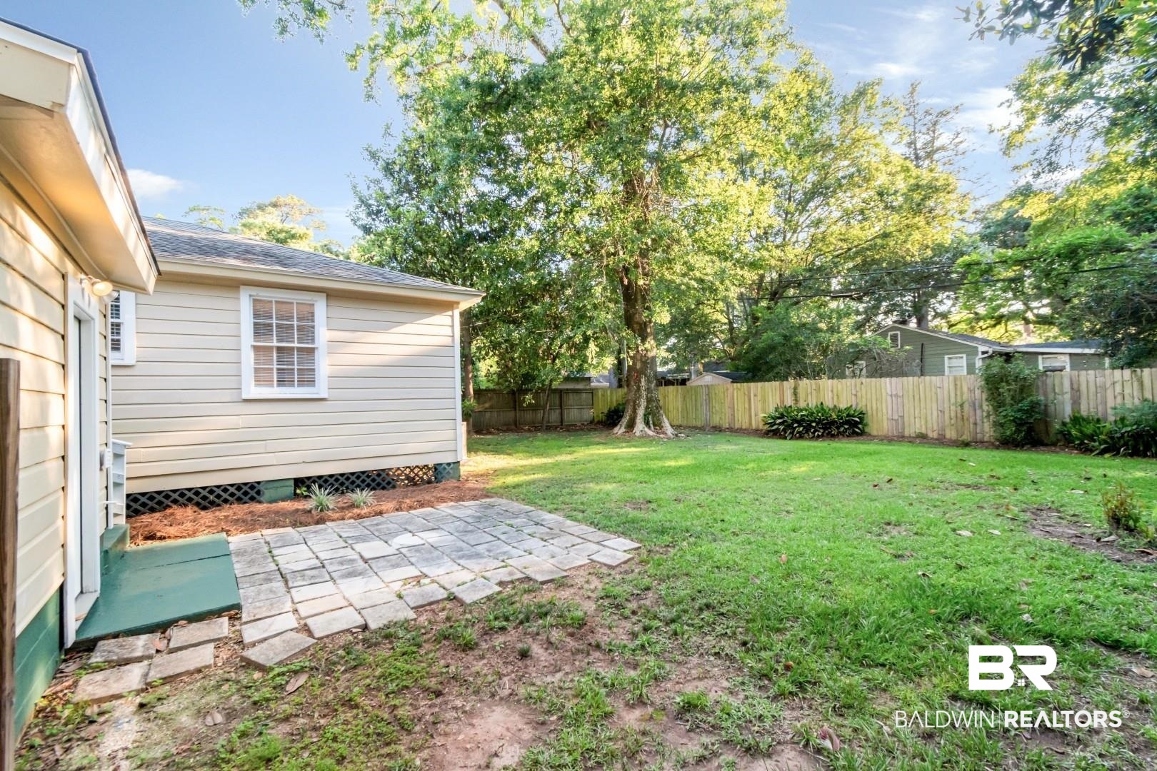 263 Border Drive East Mobile, AL 36608 - Photo 19 of 27 Expansive backyard featuring a manicured lawn, established trees, and a privacy fence
