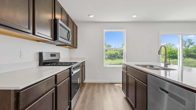 a kitchen with stainless steel appliances granite countertop a sink and a stove